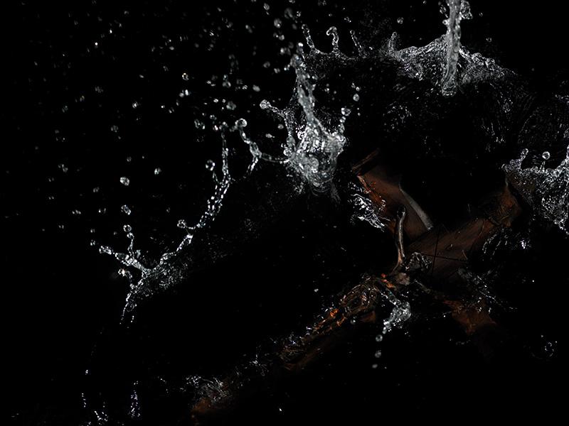 A crucifix religious Icon is thrown into water captured at the right moment of contact