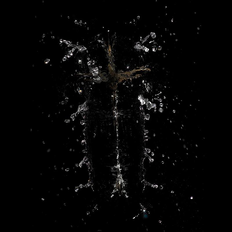 a catholic crucifix is thrown into water capturing the moment