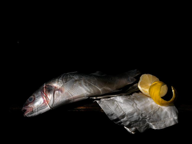 preparing a meal with fish and lemon vanitas